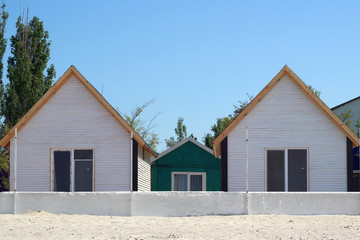 Two identical white houses with one window on the beach