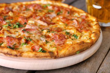 Delicious pizza  and glasses of beer are on wooden table, close up