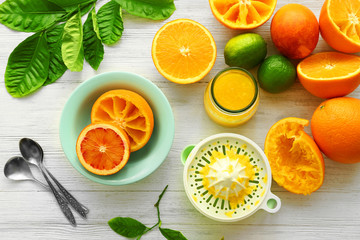 Eating oranges with spoon on white wooden background