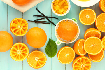 Juicing delicious oranges on light blue wooden table