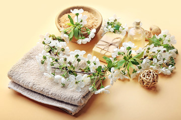 Fototapeta na wymiar Spa treatment with blooming branch on beige background