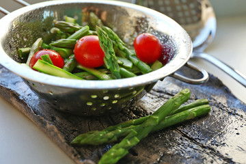 Asparagus with tomatoes in colander