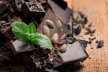Chocolate pieces with mint leaves on wooden background