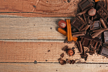 Chocolate pieces with cinnamon on wooden background