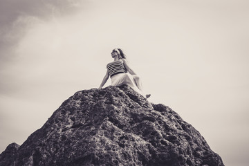 Beautiful woman sat on top of a mountain