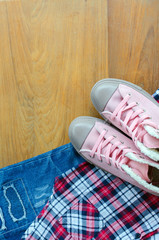 Pink sneaker, scott shirt, torn jean on wood table, Travel acces