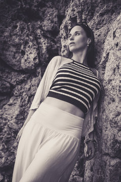 Woman leaning against the rocks