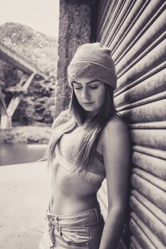 Portrait of beautiful young female model, leaning against garage