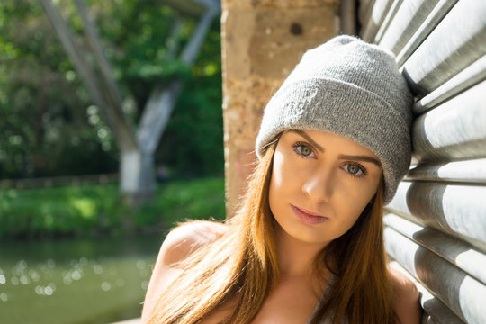 Portrait of beautiful young female model, leaning against garage