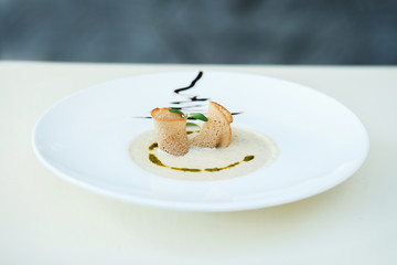 Cream soup with mushrooms and watercress salad. Soup decorated with croutons and watercress salad.