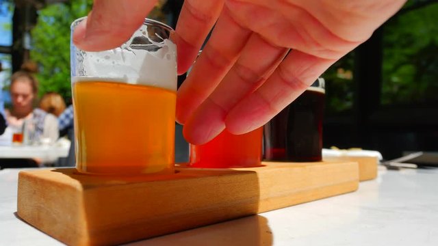 4K Pub Patio Restaurant with Beer Flight Taster Samples, Hand Holding Glass