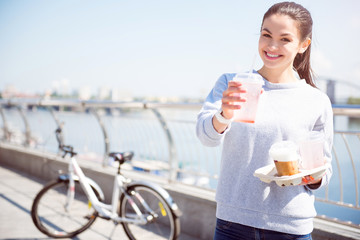 Smiling woman giving a beverage