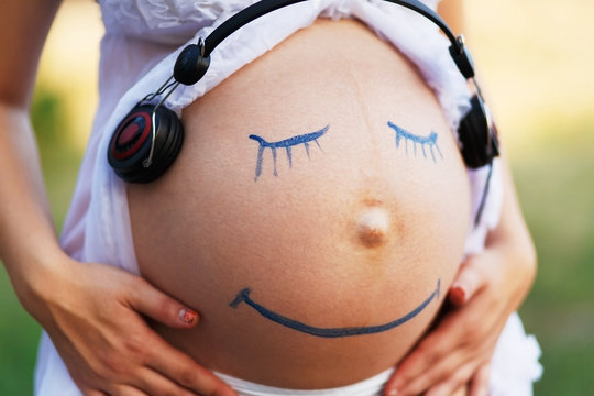 Pregnant woman belly closeup with smile funny face