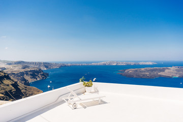 White deck chair on a luxury resort terrace with a mindblowing view of a Santorini volcanic caldera