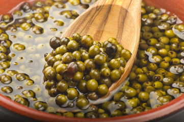 Bowl of green pepper grains close up