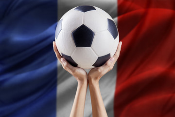 Naklejka premium Hands hold ball with flag background of France