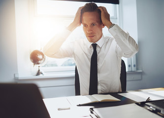 Frustrated business man looking at laptop