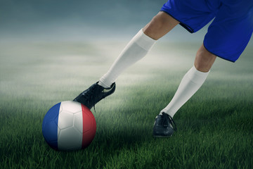 Soccer player exercises to kick a ball at field