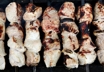 Grilling marinated shashlik on a grill