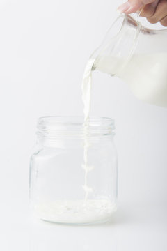 Milk pouring from a bottle in a glass isolated on a white background