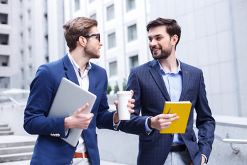 Attractive two businessmen are making a break