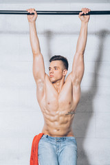 Young half naked man hanging on pipe