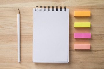 Topview of office stuff on wooden working table. Mock up. Note paper , white blank notebook,...