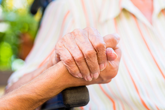 Pflegerin tröstet alte Frau im Pflegeheim oder Altenheim und hält ihre Hand