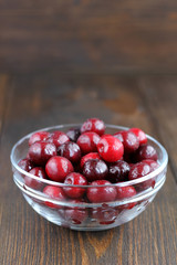 Sweet cherries in glass bowl on wooden table.