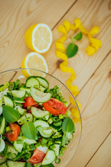 Diet plan, menu or program, tape measure and diet food of fresh vegetable salad, lemon on wood background, weight loss and detox concept, top view