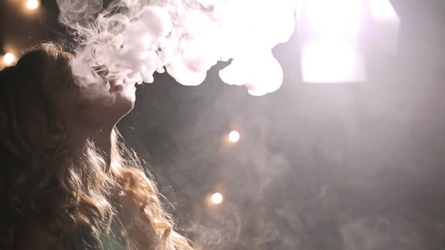 Woman smoke e cigarette, exhale thick flow, a lot of vapor fill whole frame, float smoothly