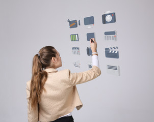 Woman pressing multimedia and entertainment icons on a virtual background
