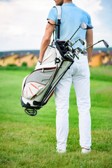Young golfer holding golf bag