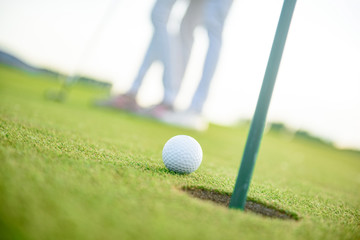 Close up of golf ball next to hole