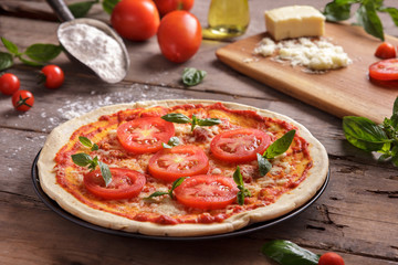 italian homemade pizza with sliced tomato topping