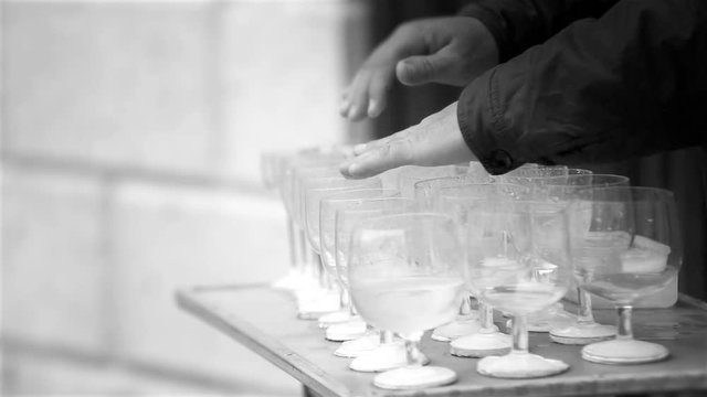 Black and white footage of a busker playing the wine glasses