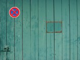 "Strenges Halteverbot an einer Garagenausfahrt mit altem grünen Holztor