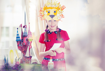 Obraz na płótnie Canvas Little girl demonstrating her art craft works, Paper masher fairy castle and Lion mask she made. Educational and creative concept.