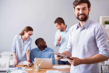 Positive smiling man standing in the office