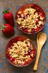 Erdbeer und Rhabarber Crumble oder Crisp, ein gebackenes Dessert  bestehend aus Obst und Haferflockenstreusel, fotografiert mit natürlichem Licht