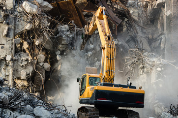 Excavator working at the demolition of an old industrial buildin - obrazy, fototapety, plakaty