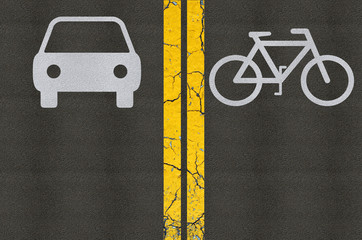 Reserved lanes for bikes and cars on asphalt separated by two ye
