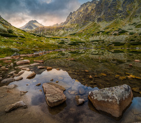 Mountain Lake Above Skok Waterfall with Rocks in Foreground and Strbsky Peak in Background at Sunset. Mlynicka Valley, High Tatra, Slovakia. © kaycco