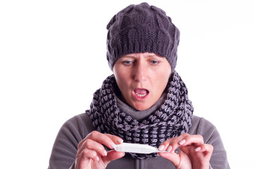 Frau blickt schockiert auf Schwangerschaftstest