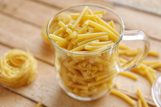 Maccheroni in a glass cup on wooden table background