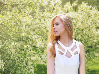 Young beautiful woman on blooming tree background