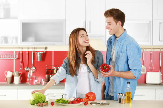 Couple cooking salad in kitchen