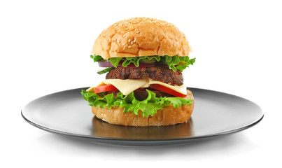 Big hamburger on a black plate isolated on white