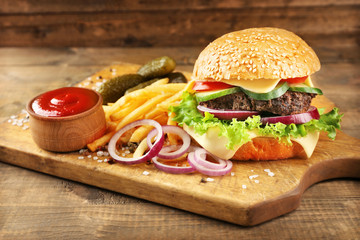 Hamburger with fries on wooden background