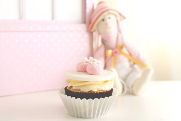 Toy and cupcake on light background